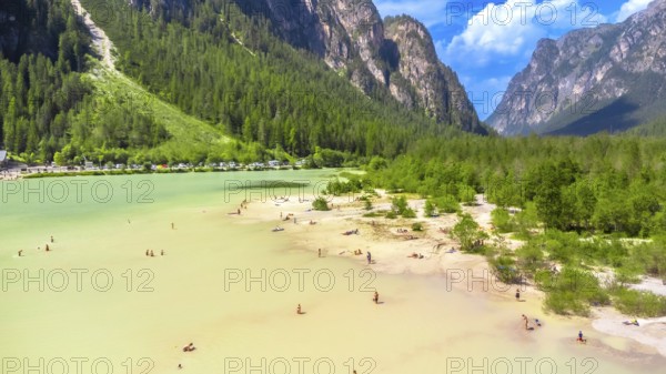 Tourists enjoying summer at lago di landro, also known as durrensee lake, surrounded by the stunning dolomites mountain range in trentino alto adige, italy