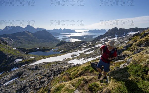 View of mountains and fjord landscape, mountaineers at the summit of Rundfjellet, Austenesfjord and Hellskarvatnet lake, Svolvaer, Nordland, Norway, Europe