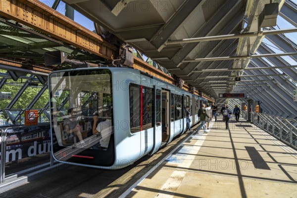 The Wuppertal suspension railway, train of the latest generation 15, floats above the Wupper, Wuppertal-Ohligsmühle station, North Rhine-Westphalia, Germany, Europe