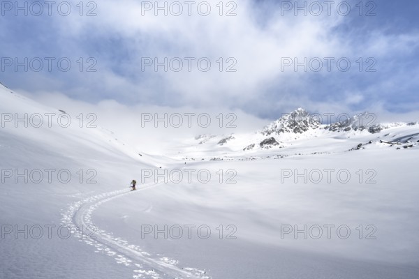 Ski tourers ascending through a picturesque snow-covered mountain landscape with peaks, ascent to the summit of Kesch Pitschen, Bündner Haute Route ski tour, Albula Alps, Rhaetian Alps, Grisons, Eastern Switzerland, Switzerland, Europe