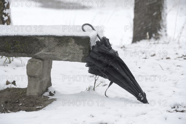 Umbrella Leaning on a Bench with Snow in Winter in a Park in Locarno, Ticino, Switzerland, Europe