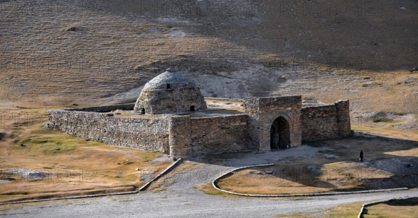 Historic caravanserai Tash Rabat from the 15th century, with yellow hills, Atbashy district in the Naryn region, Kyrgyzstan, Asia