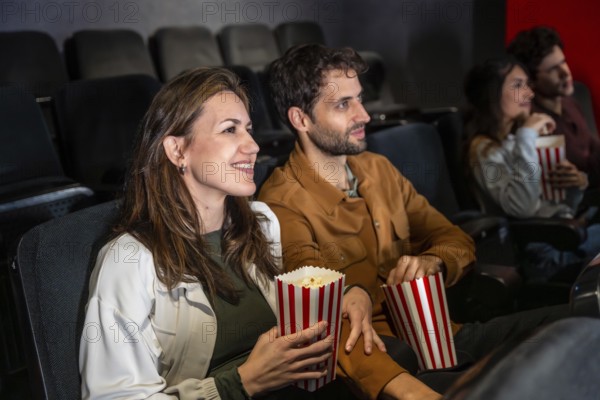 Group of friends enjoying a movie at the cinema, sharing laughter and popcorn while soaking in the excitement of the big screen