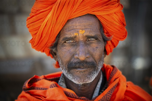Man with orange turban and yellow bindi on his forehead, portrait, Chittorgarh Fort, Chittorgarh, Rajasthan, India, Asia