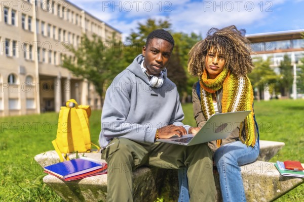 Young multiethnic female and male students using laptop and preparing for the next lecture