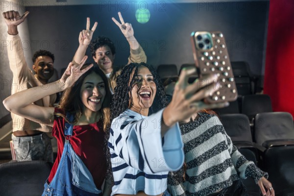 Young people taking a selfie at the movie theater during a disco dance event, having fun and enjoying the moment