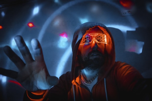 Bearded man with futuristic orange glasses interacting with holographic interface in virtual reality environment