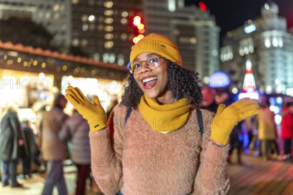 Young woman wearing yellow winter clothes expressing joy at christmas market in manezhnaya square, moscow, russia