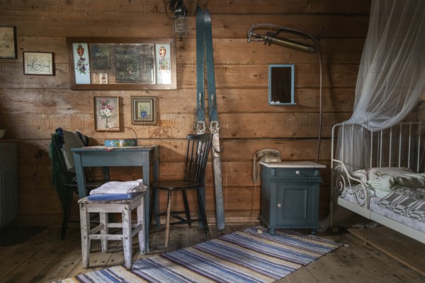 Interior of a traditional Norwegian wooden storehouse or Stabbur with old furniture and skis on the wall, Leirsund, Norway, Europe