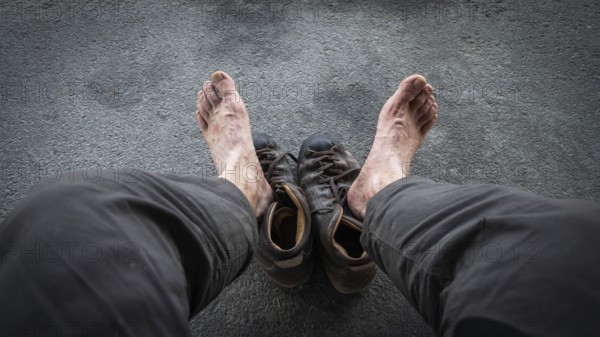 View of two bare feet of a pilgrim, worn hiking boots on dark ground, pilgrimage route Olavsweg or Olavsleden, Hamar, Norway, Europe