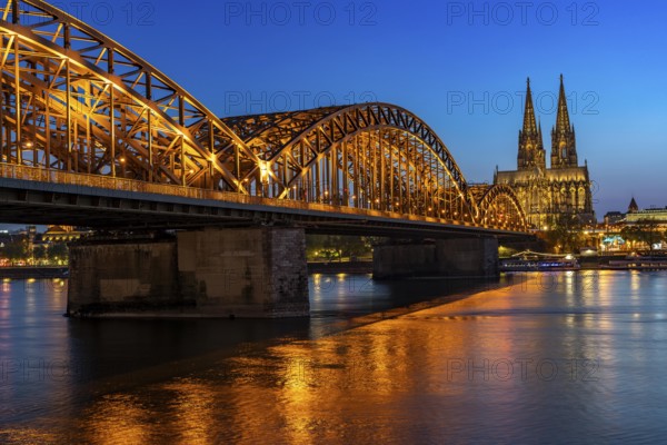 Cologne Cathedral, has been shining in new light since Easter 2025, the old metal halide lamps have been replaced by over 700 modern LED lamps, reducing energy consumption by around four fifths, significantly improving the quality of light and greatly reducing light emissions, 12 KM of new cables were laid for this, Hohenzollern Bridge, railway bridge over the Rhine, North Rhine-Westphalia, Germany, Europe