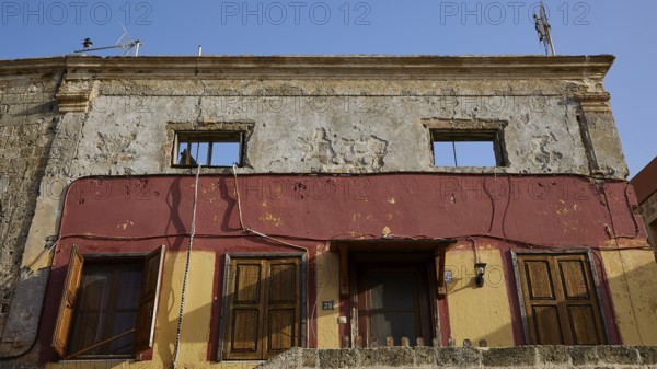 Old building with damaged walls, two windows and doors painted in yellow and red, Rhodes Old Town, Rhodes Town, Rhodes, Dodecanese, Greek Islands, Greece, Europe