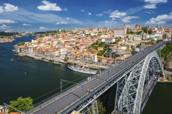 View of Porto city and Douro river with moored sailing ship and Dom Luis bridge I from famous tourist viewpoint Miradouro da Serra do Pilar on sunset. Porto, Vila Nova de Gaia, Portugal, Europe