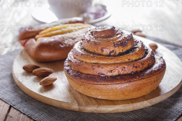A cup of hot chocolate and buns on brown wooden background. close up