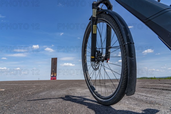 Cycling in the Ruhr area, on the Schurenbach slag heap, Bramme landmark for the Ruhr area by artist Richard Serra, Essen, North Rhine-Westphalia, Germany, Europe