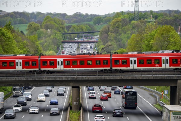 S-Bahn train crossing the motorway A3, traffic on 8 lanes, incl. the temporarily released hard shoulder, behind the motorway junction Hilden, view in north direction, near Erkrath, North Rhine-Westphalia, Germany, Europe