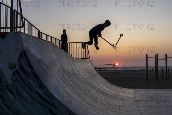 Skater, scooter in a halfpipe at the beach of Scheveningen, sunset, Netherlands