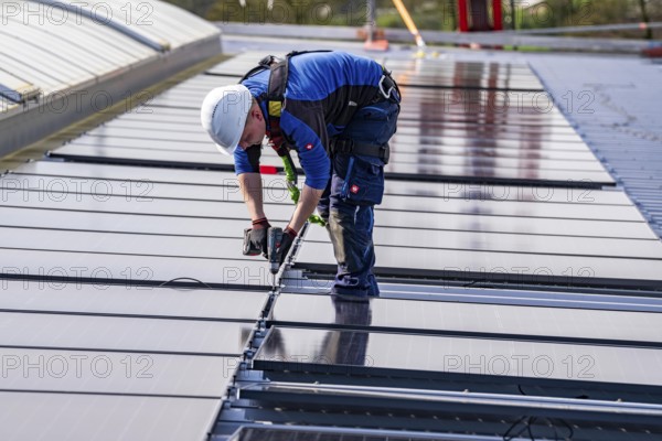Installation of solar modules on the roof of a commercial enterprise, over 400 photovoltaic modules are installed on the roof, North Rhine-Westphalia, Germany, Europe