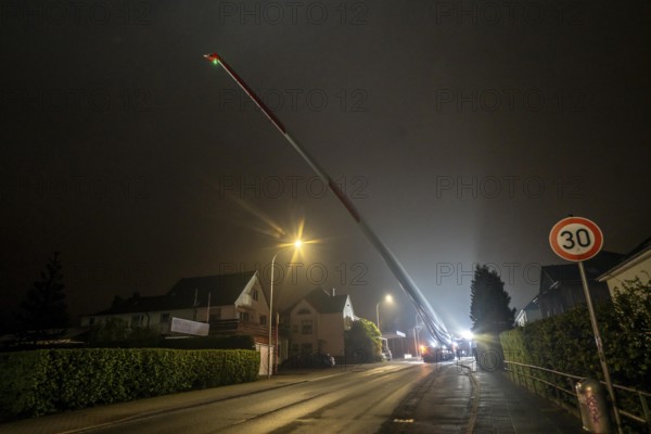Transport of a 68 metre long, 22 tonne blade of a wind turbine, here in Breckerfeld, with a self-propelled Blade-Lifter vehicle, over a 40 km long route, over 2 nights, in the Bergisches Land, through towns, villages, over country roads, narrow through roads, to the construction site of the wind turbine near Hagen, North Rhine-Westphalia, Germany, Europe