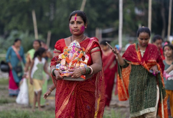 Devotees carries the Ganesha idol to immerse in the Brahmaputra river, during Ganesh Chaturthi festival, in Guwahati, Assam, India on Saturday, 9 Sept 2024