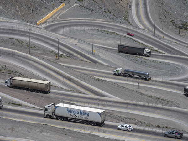 Heavy traffic of trucks on mountain pass Los Caracoles, The Snails, road connecting Chile and Argentina, aerial view, Chile, South America