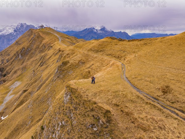 A couple stands on a hill path with far-reaching mountain views, Alpen Tower, Switzerland, Europe