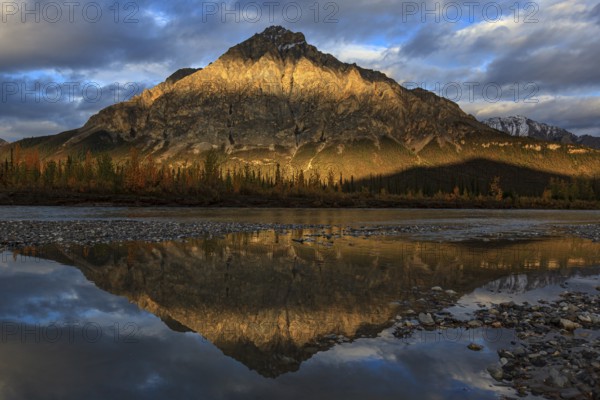 Clouds and evening light over mountains, mountain reflected in water, autumn, Brooks Range, Alaska, USA, North America