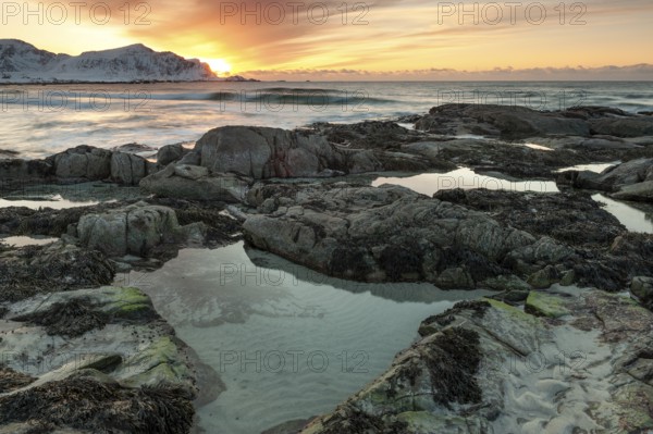 Sunset in winter at Skagsanden, rocks on the beach at Flakstad, Flakstadøy, Lofoten, Nordland, Norway, Europe