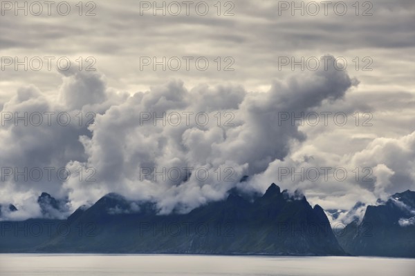 Mystical landscape with dramatic mountain peaks and clouds over the sea, Norway, Europe