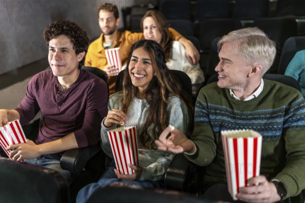 Happy friends enjoying a movie at the cinema, sharing popcorn, laughing, and creating unforgettable memories together