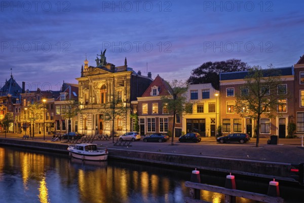 Canal with boats and houses illuminated in the evening. Haarlem, Netherlands