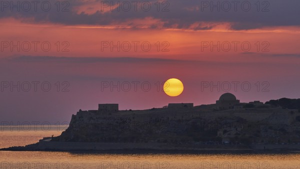 Sunrise, orange sunball over Venetian fortress, red sky, grey clouds, silhouette, backlight, Fortezza, Venetian sea fortress, Rethimnon, central Crete, island of Crete, Greece, Europe