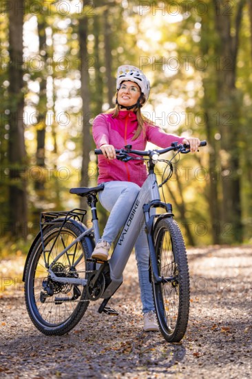 Woman on Ebike through the autumn forest, Black Forest, Gechingen, Germany, Europe