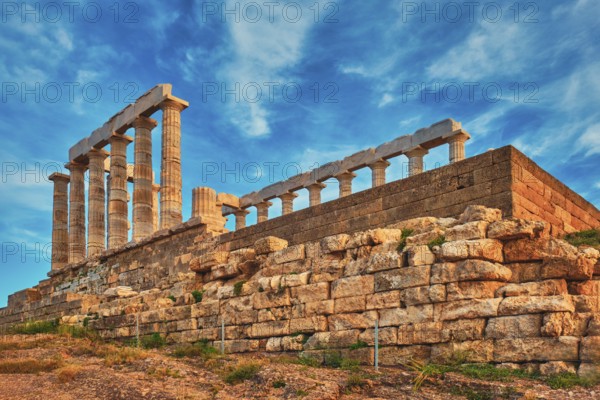 Greece Cape Sounio. Ruins of an ancient temple of Poseidon, Greek god of the sea, on sunset. Shot of temple ruins on sunset. Tourist landmark of Attica, Sounion, Greece, Europe