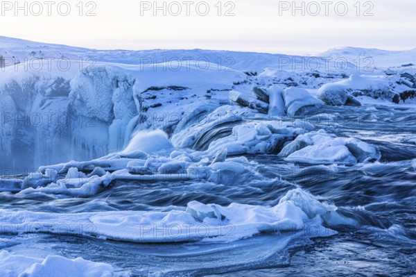 Icefall at the edge of the Godafoss waterfall at dawn, snow-covered landscape, Northern Iceland Eyestra, Iceland, Europe