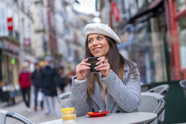 French style woman smiling looking away sitting in an outdoor cafeteria