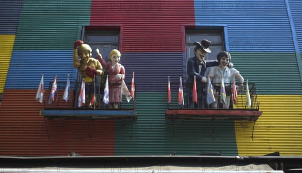 Colourful house facades with balconies and figures, decorated with flags, La Boca district, Buenos Aires, Argentina, South America