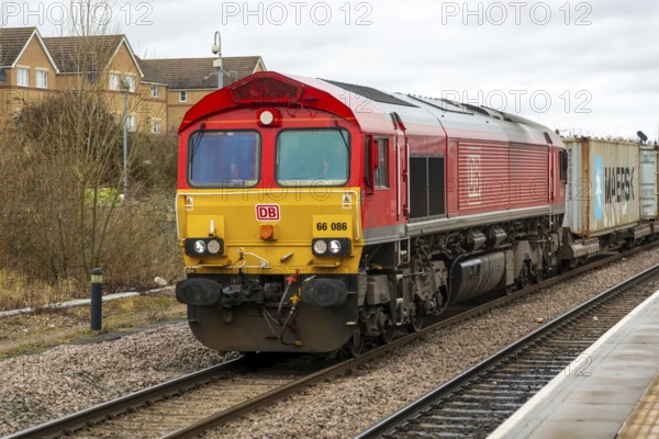 DB Cargo Class 66 freight train passing through Peterborough railway station, Cambridgeshire, England, UK