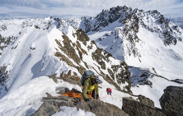 Mountaineer belaying on a steep snow slope, belaying on a rope, ascent to the summit of Piz Grialetsch in winter, view of mountain panorama with snow, Grisons Haute Route, Albula Alps, Rhaetian Alps, Grisons, Switzerland, Europe