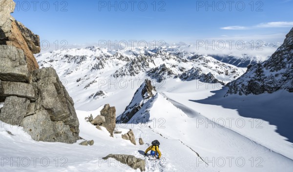 Mountaineer with ice axe and crampons, ascent through steep snowfield to Piz Kesch or Piz d'Es-cha in winter, view of mountain panorama with Vadret da Porchabella glacier, Albula Alps, Rhaetian Alps, Grisons, Eastern Switzerland, Switzerland, Europe