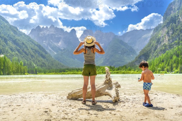 Mother and son enjoying a sunny day at lago di landro, surrounded by the stunning dolomites in south tyrol, italy