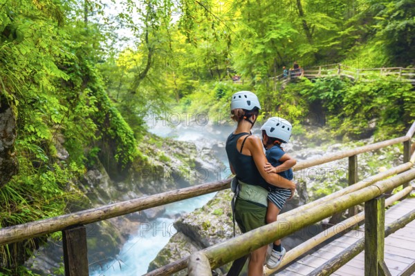 Mother holding her child while admiring the stunning vintgar gorge near bled, slovenia, during summer
