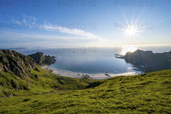View of picturesque coastal landscape with sun star, Høyvika beach and sea, hike to the summit of Måtind, Andøya island, Vesterålen, Nordland, Norway, Europe