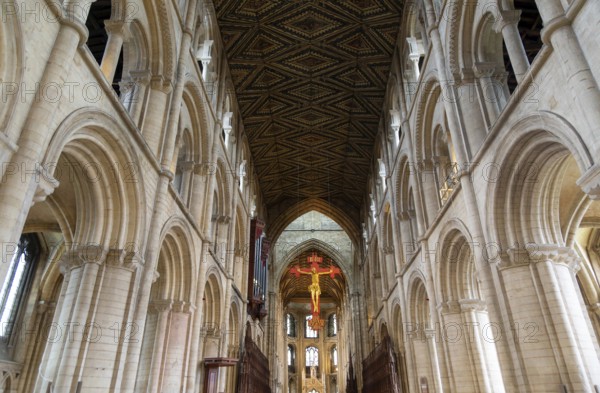 Interior of cathedral church, Peterborough, Cambridgeshire, England, UK looking up at ceiling and sculpture of Jesus Christ on Cross