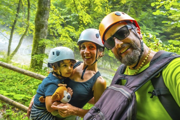 Smiling family wearing helmets taking a selfie while hiking in the beautiful vintgar gorge near bled, slovenia, during summer