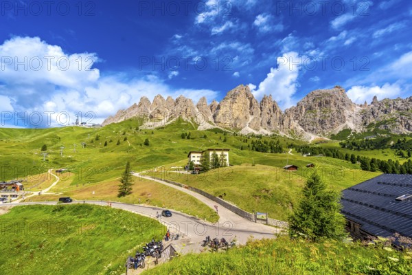 Breathtaking view of the majestic dolomites group mountains and the winding road of passo gardena during a sunny summer day
