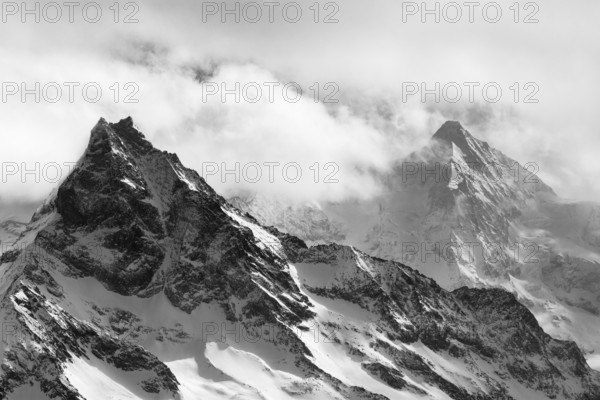 Fog envelops the snowy summit of the mountain Le Besso, Val d'Anniviers, Valais Alps, Canton Valais, Switzerland, Europe