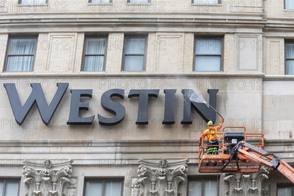 Detroit, Michigan - A worker uses a high-pressure water spray to clean the exterior of the 100-year-old Westin Book Cadillac Hotel