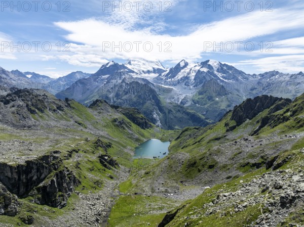 Mountain stream and mountain lake Lac de Louvie with glaciated summit of the Grand Combin, Val de Bagnes, Valais, Switzerland, Europe