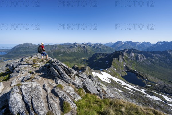 View of mountains and fjord landscape, mountaineers at the summit of Rundfjellet, Lake Hellskarvatnet, Svolvaer, Nordland, Norway, Europe